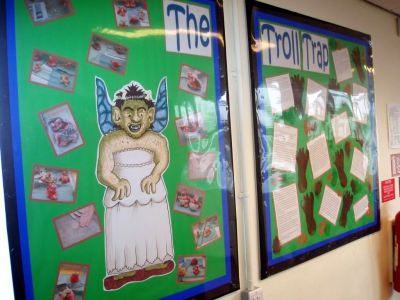 Photographs of clay trolls on the classroom wall.